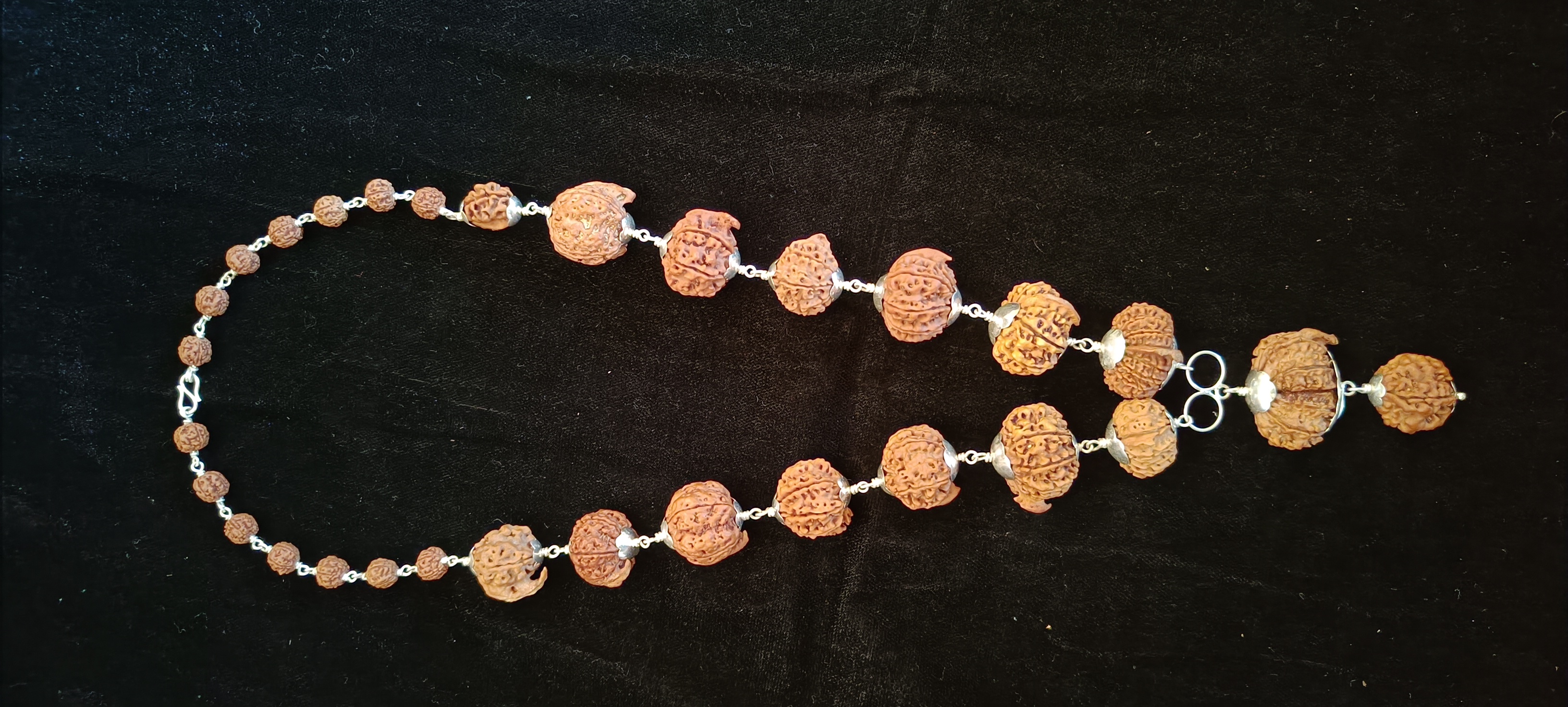 The clasp and the smaller beads at the back of the mala